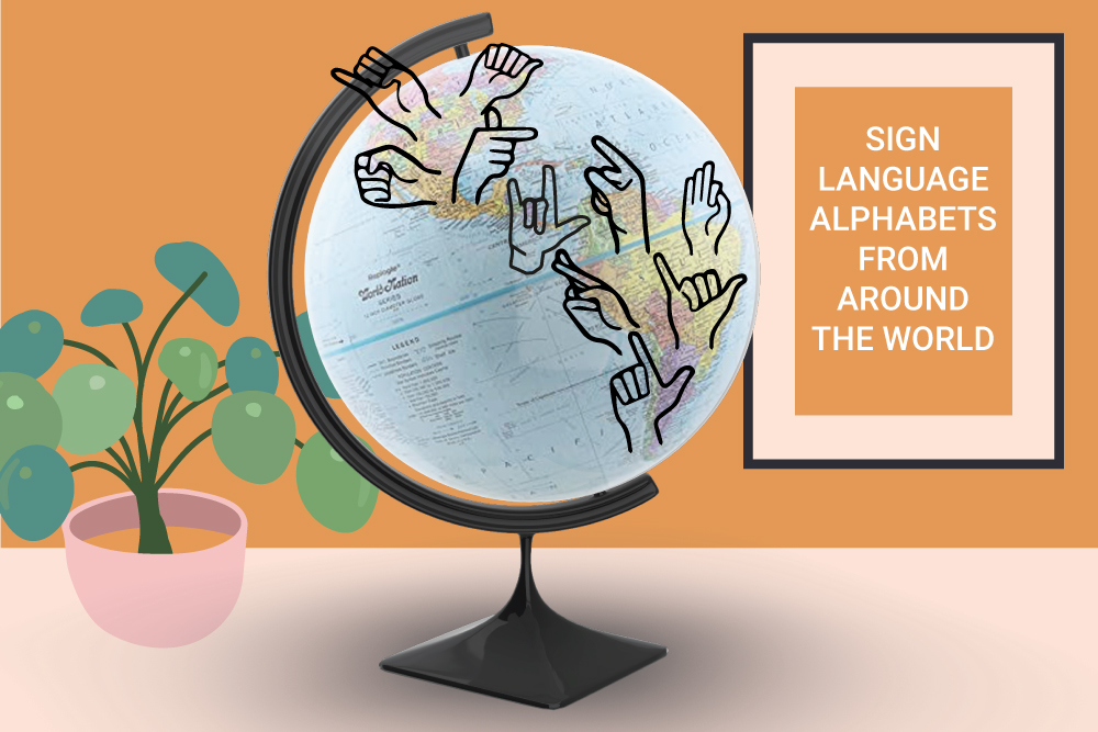 A globe on a desk with a world map on it. On the map are hands doing letters in sign language. There is also a plant on the desk and a frame.